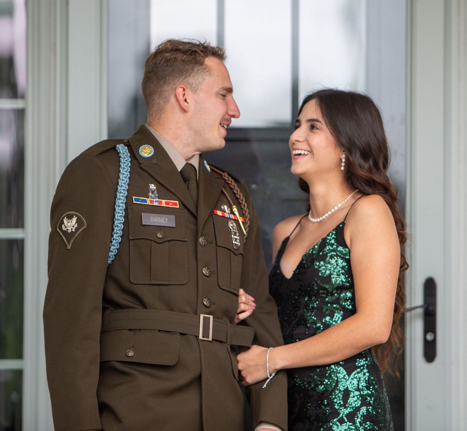 Photograph by Allie of a couple smiling at each other before a military ball, with the man wearing his U.S. Army dress uniform and the woman