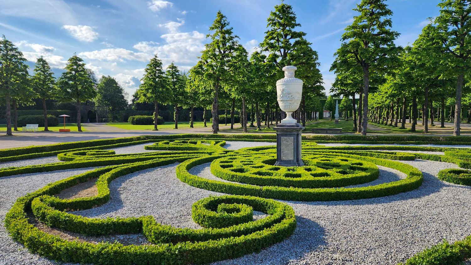 Photograph by Allie of the Schwetzingen Palace Gardens in Germany, featuring intricate swirling hedges, and a manicured lawn.