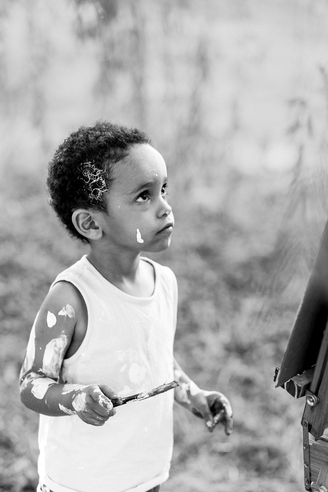 Portrait d'un enfant qui peint à Angers pendant une séance famille en extérieur avec un photographe à Angers