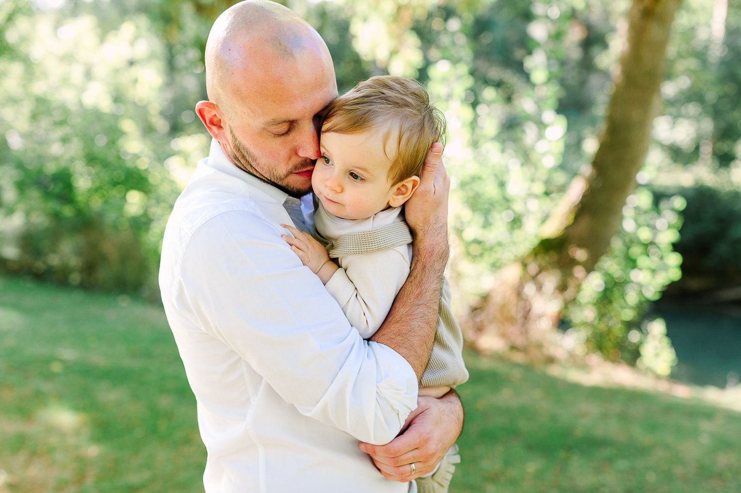 papa fait un câlin à son enfant dans un parc d'Angers lors d'une séance photo avec une photographe d'Angers