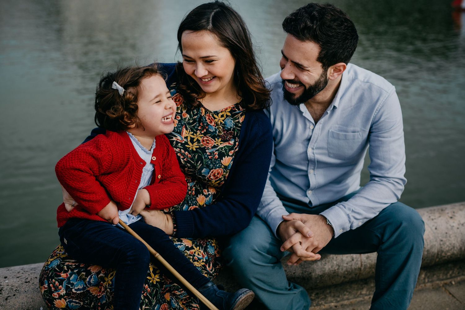 Instant complice entre parents et enfants photographié au bord d'un lac par un photographe famille à Angers