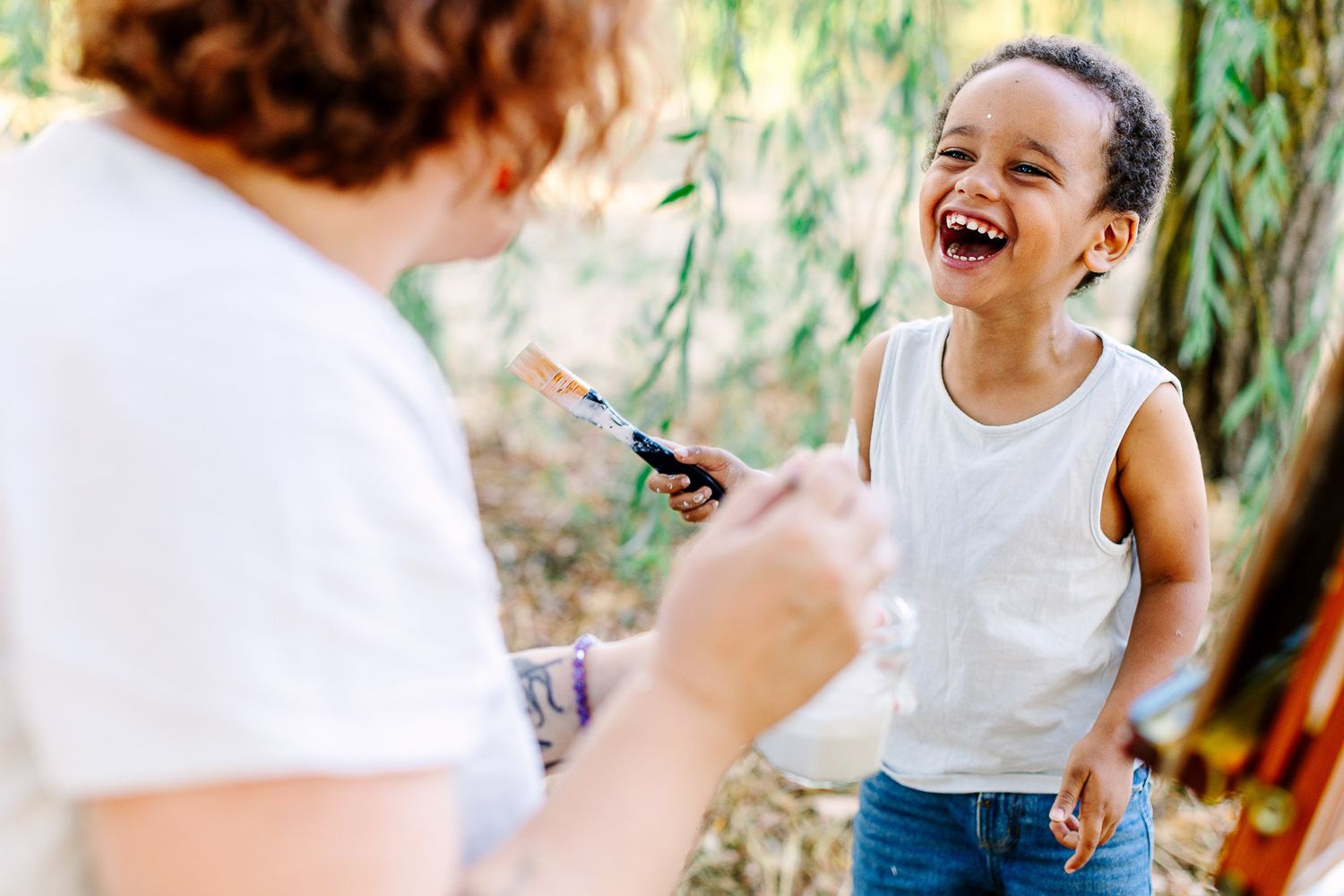Maman et enfant partageant un moment de complicité à Angers pendant une séance photo famille en faisant de la peinture ensemble