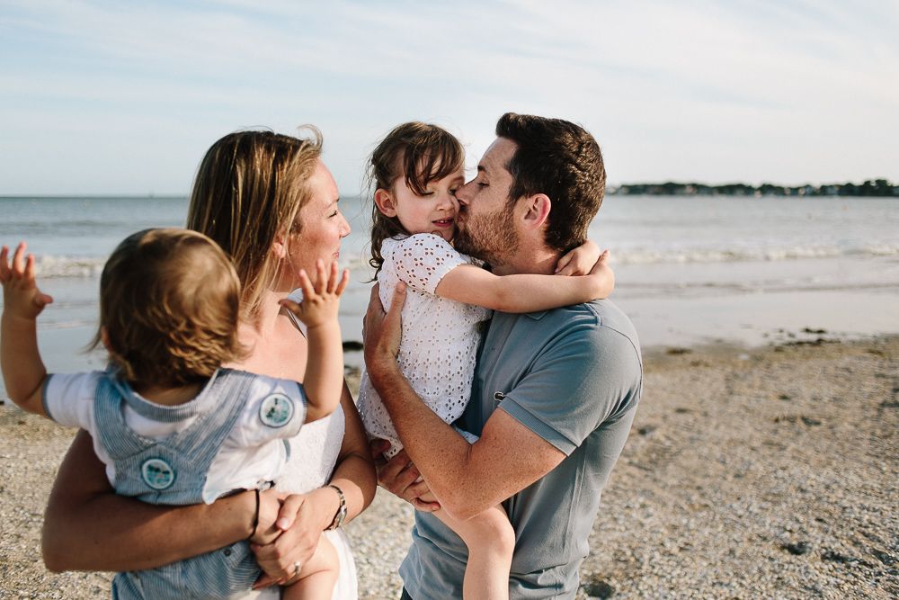 famille qui partage un moment de complicité au bord de la mer lors d'une séance photo avec une photographe d'Angers