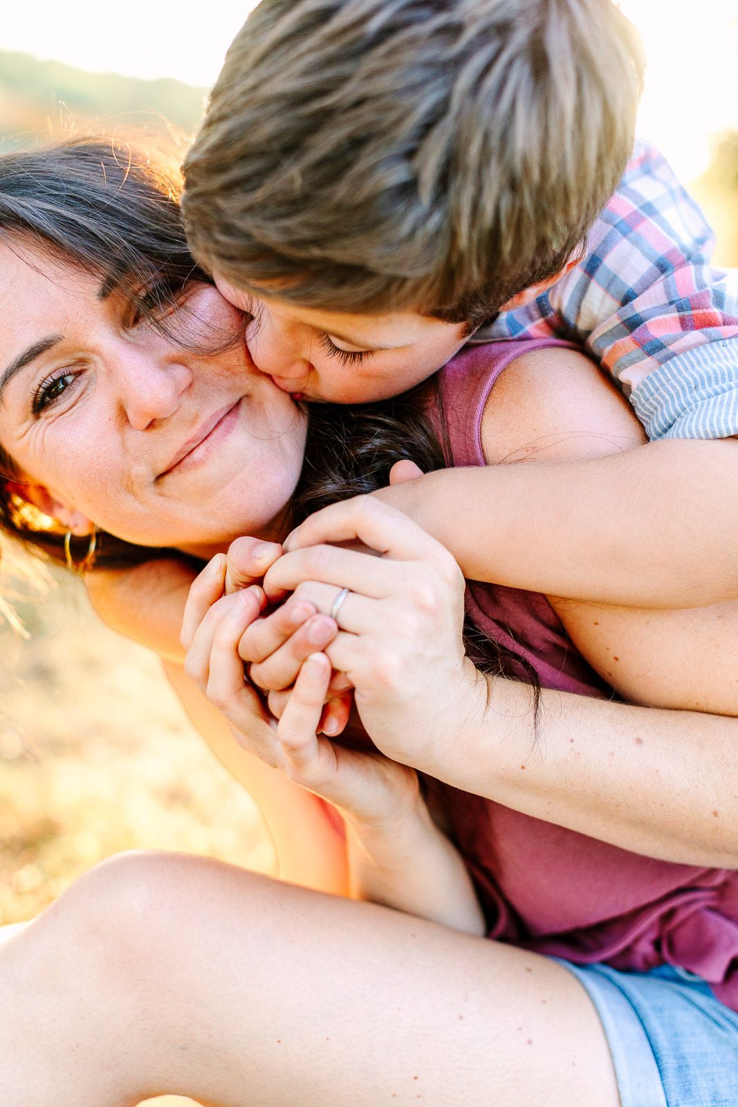 séance photo famille un enfant fait un bisou à sa maman