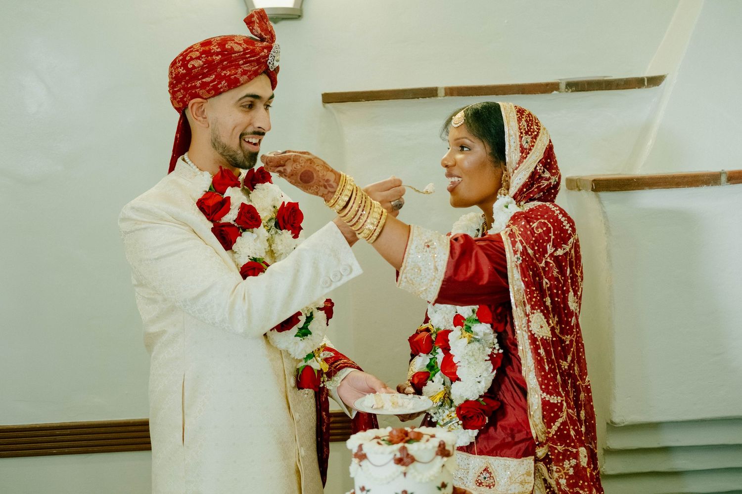 The bride and groom share a piece of wedding cake during their reception celebration.