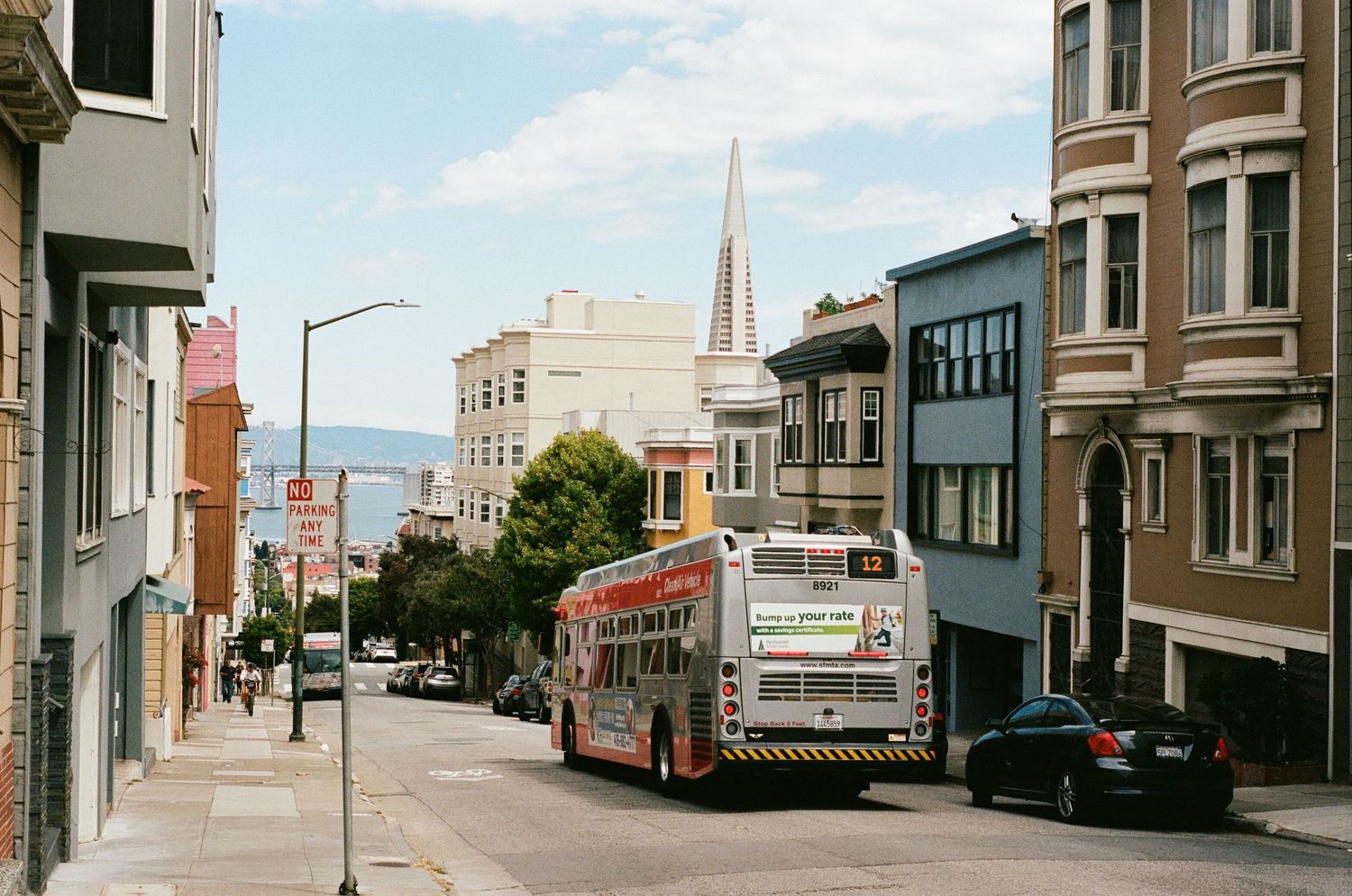 A bus drives down a hilly street in San Francisco.