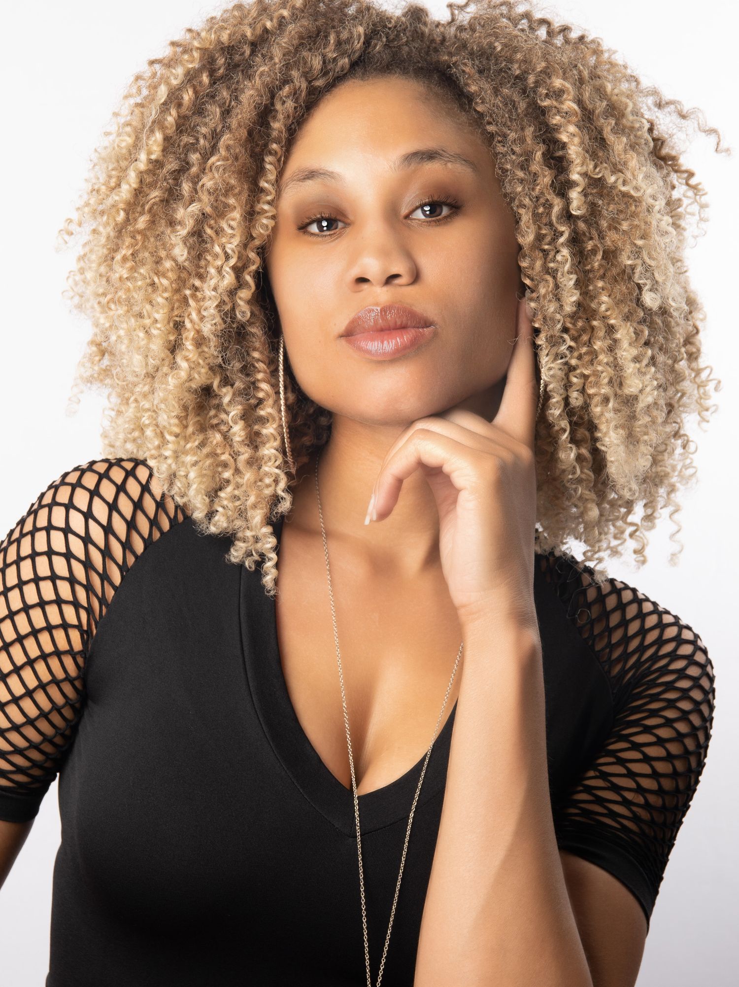 Professional headshot of a woman with curly hair against a light background.