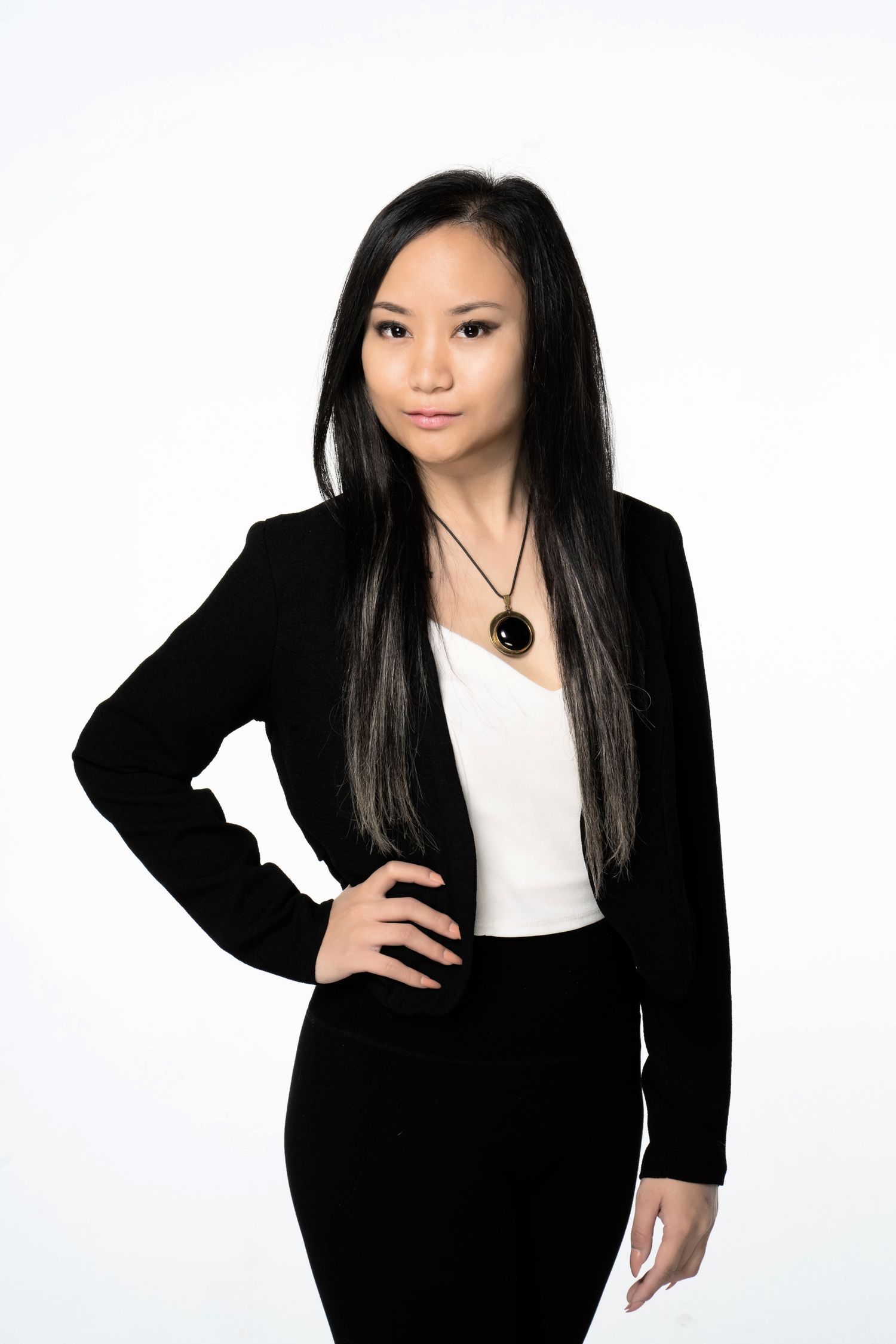 Professional woman in a black blazer posing against a white backdrop.