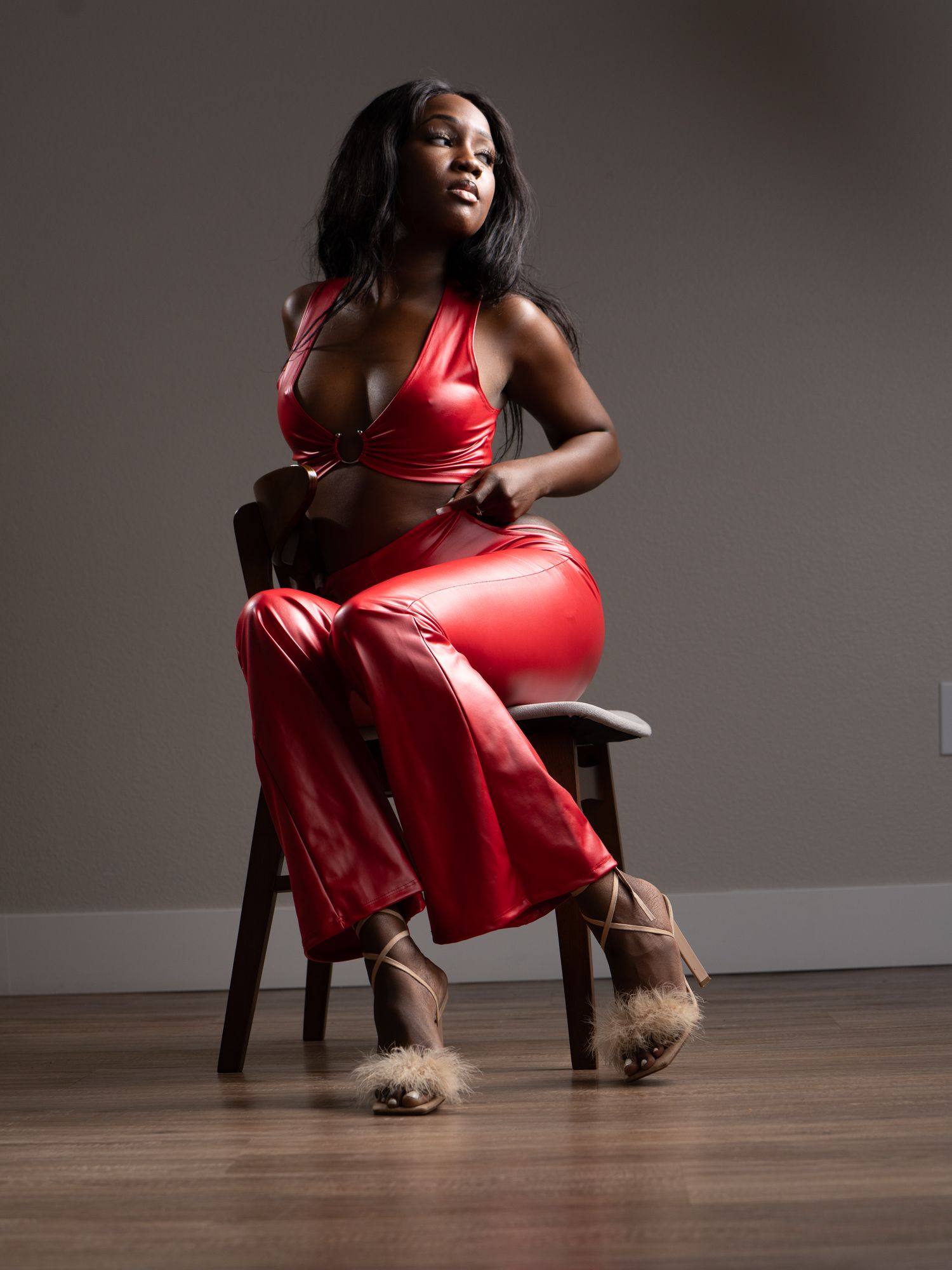 Woman in a red dress seated for a polished personal branding portrait.