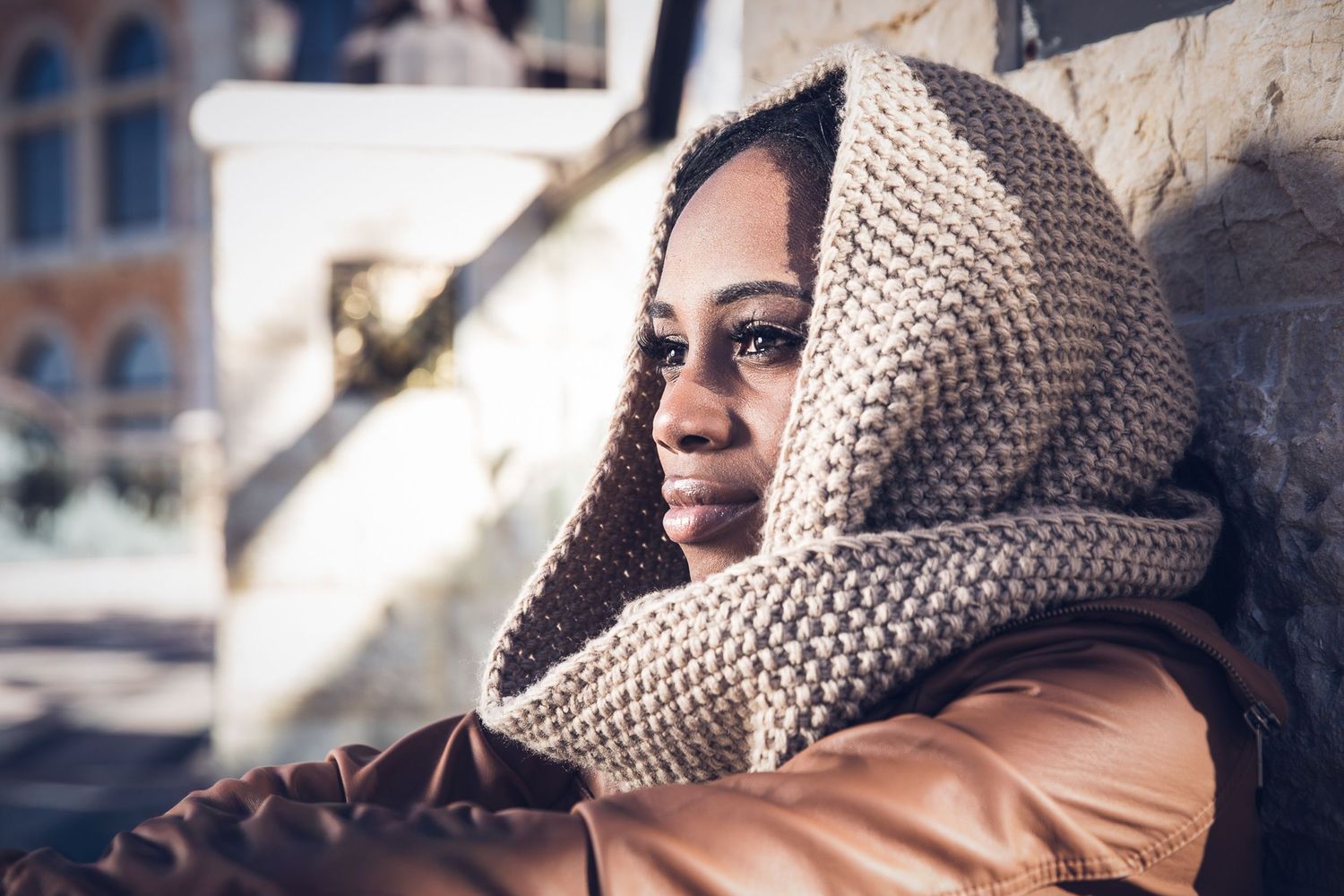 Outdoor portrait of a woman wrapped in a textured scarf and coat.
