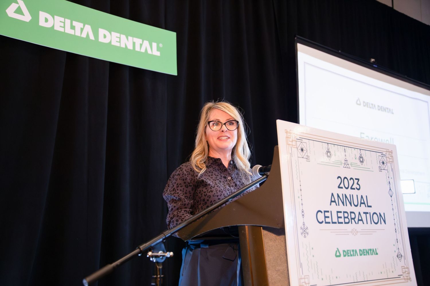 Woman speaking at a Delta Dental annual celebration podium.
