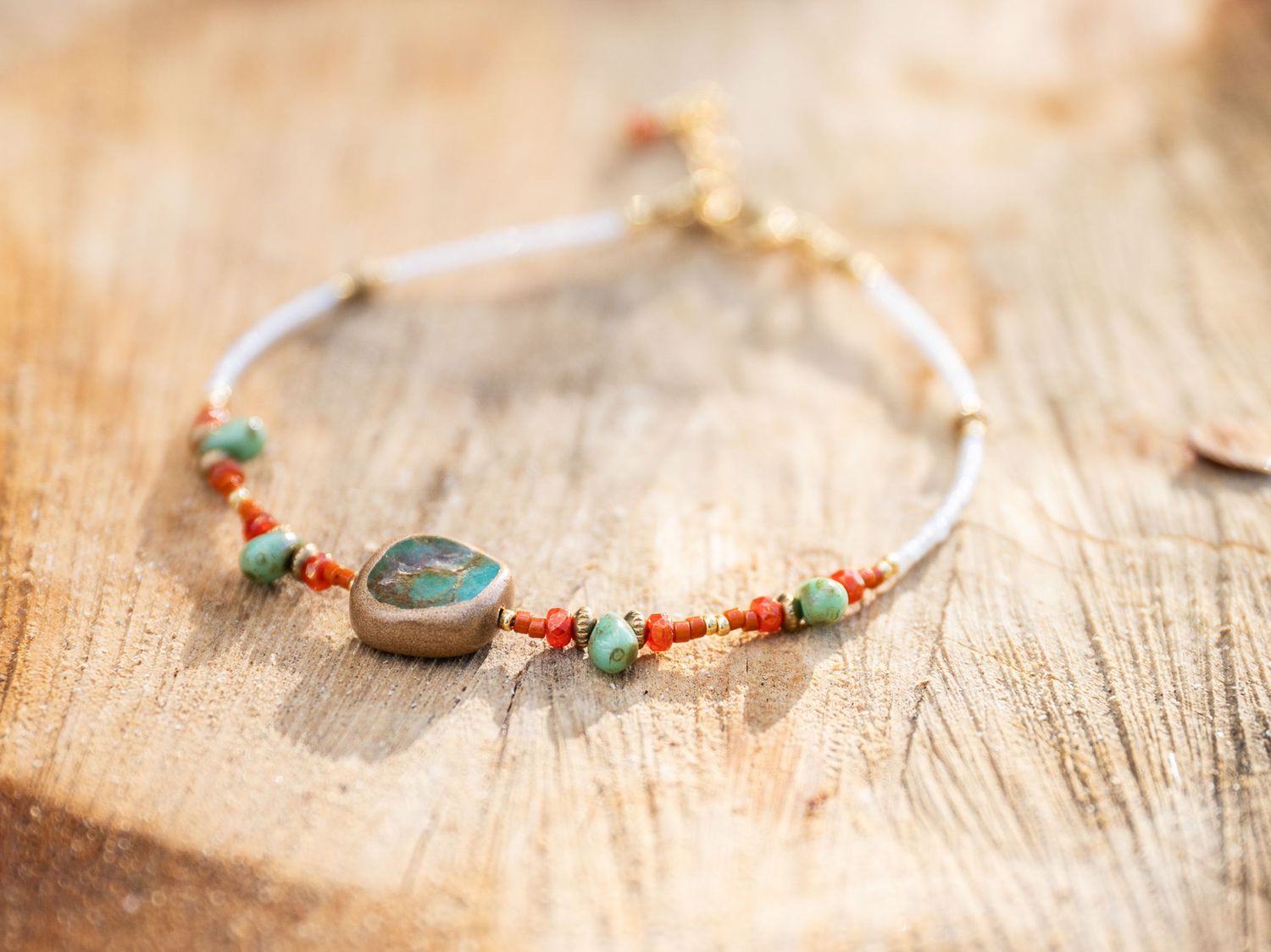 Handcrafted beaded bracelet displayed on a rustic wooden surface.