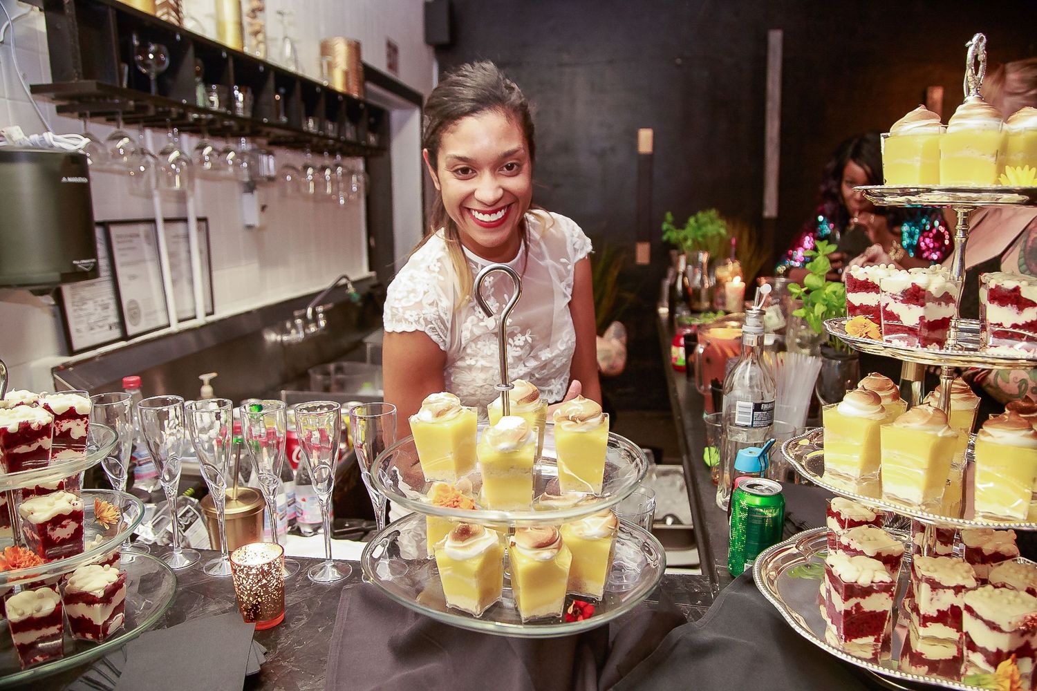 Event professional serving drinks and desserts during a lively reception.