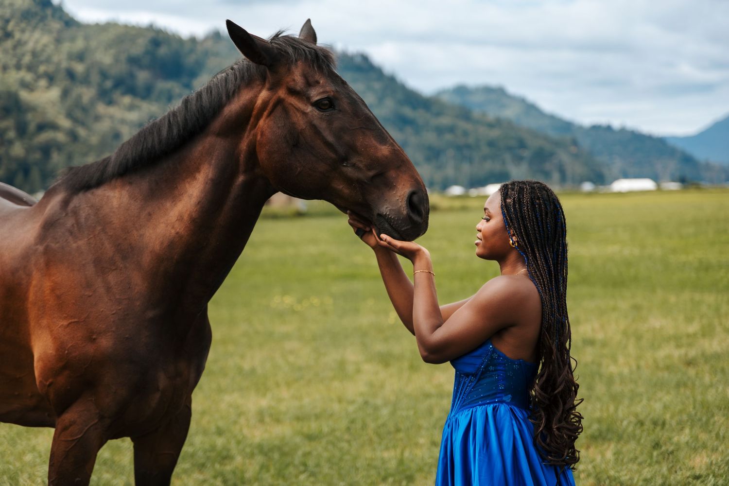 girl standing with horse in a large field in a graduation dress. Edmonton equine photographers. Family pictures with horses on a farm