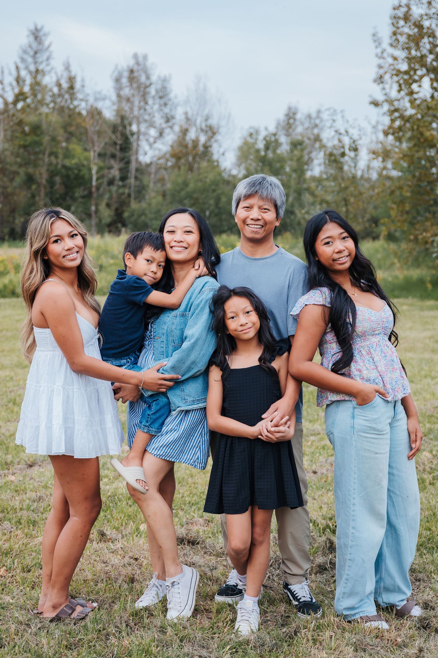 edmonton area family and wedding photographer. Outdoor family pictures. Spruce grove photographers. parents stand with 4 kids in a field