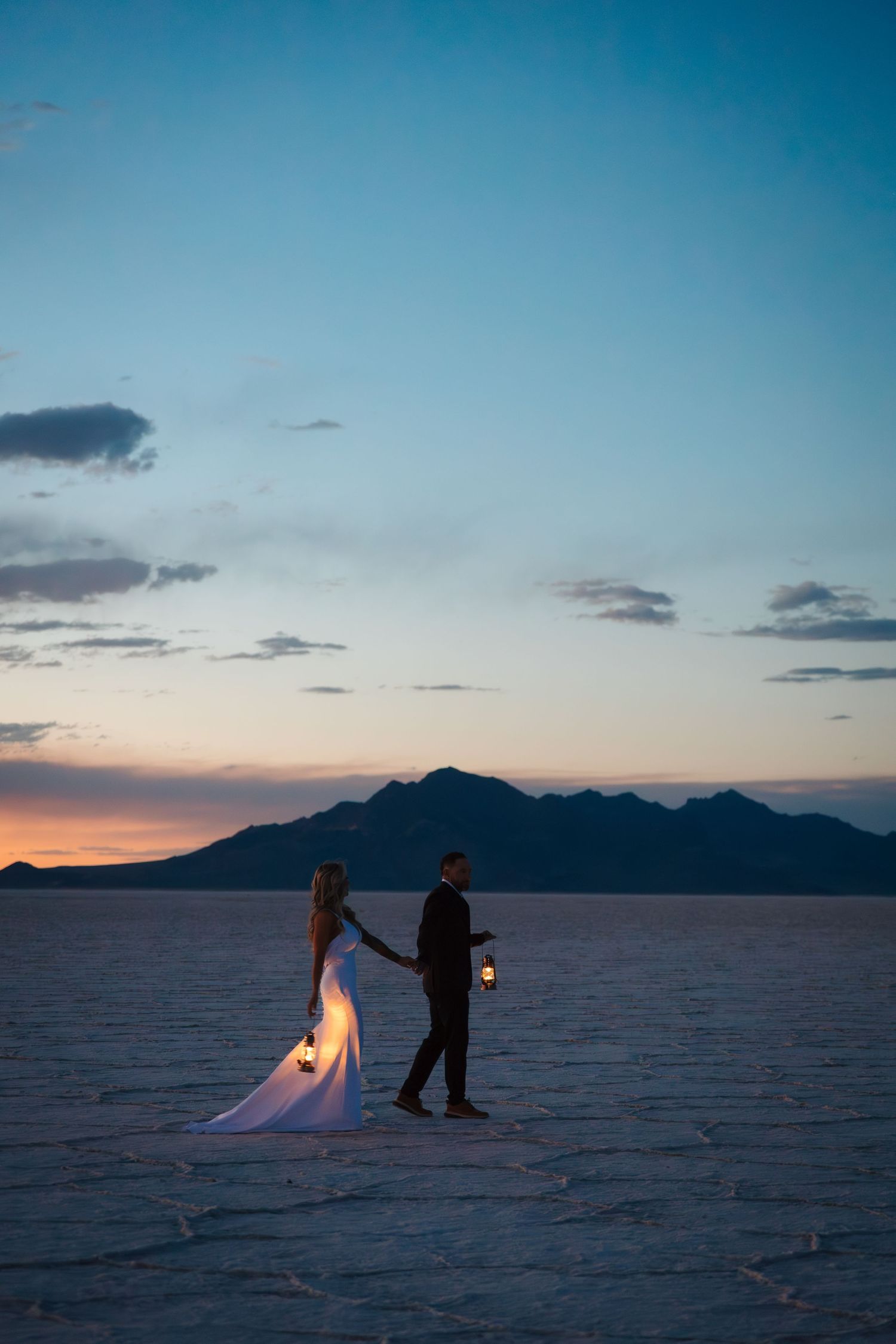 bride and groom walk in moonlight holding lanterns. Mexico wedding pictures on the beach. Leduc family and branding photographer