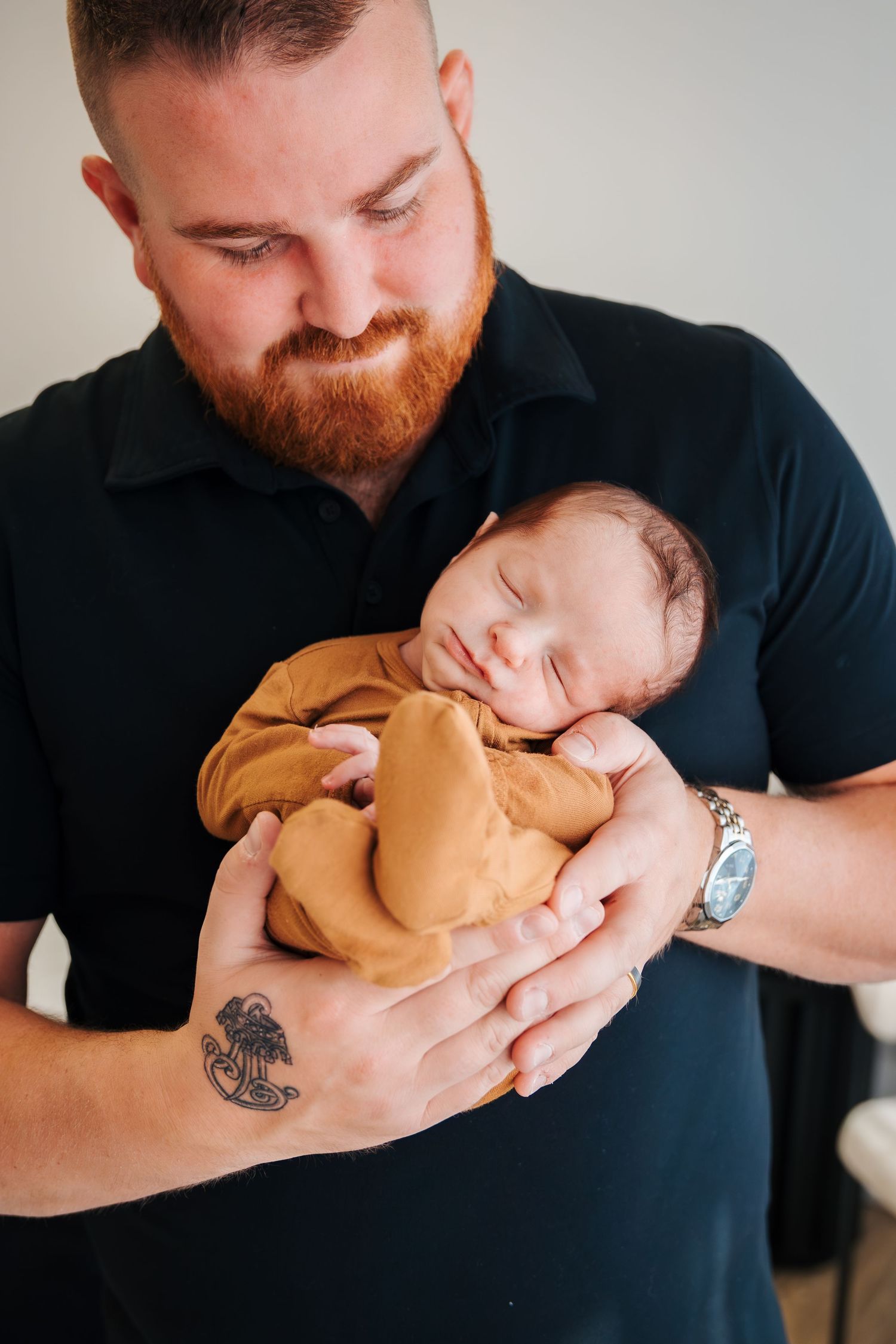 Dad holding baby boy. maternity and newborn photographers in edmonton spruce grove and st.albert. Newborn pictures at home. Lifestyle photos