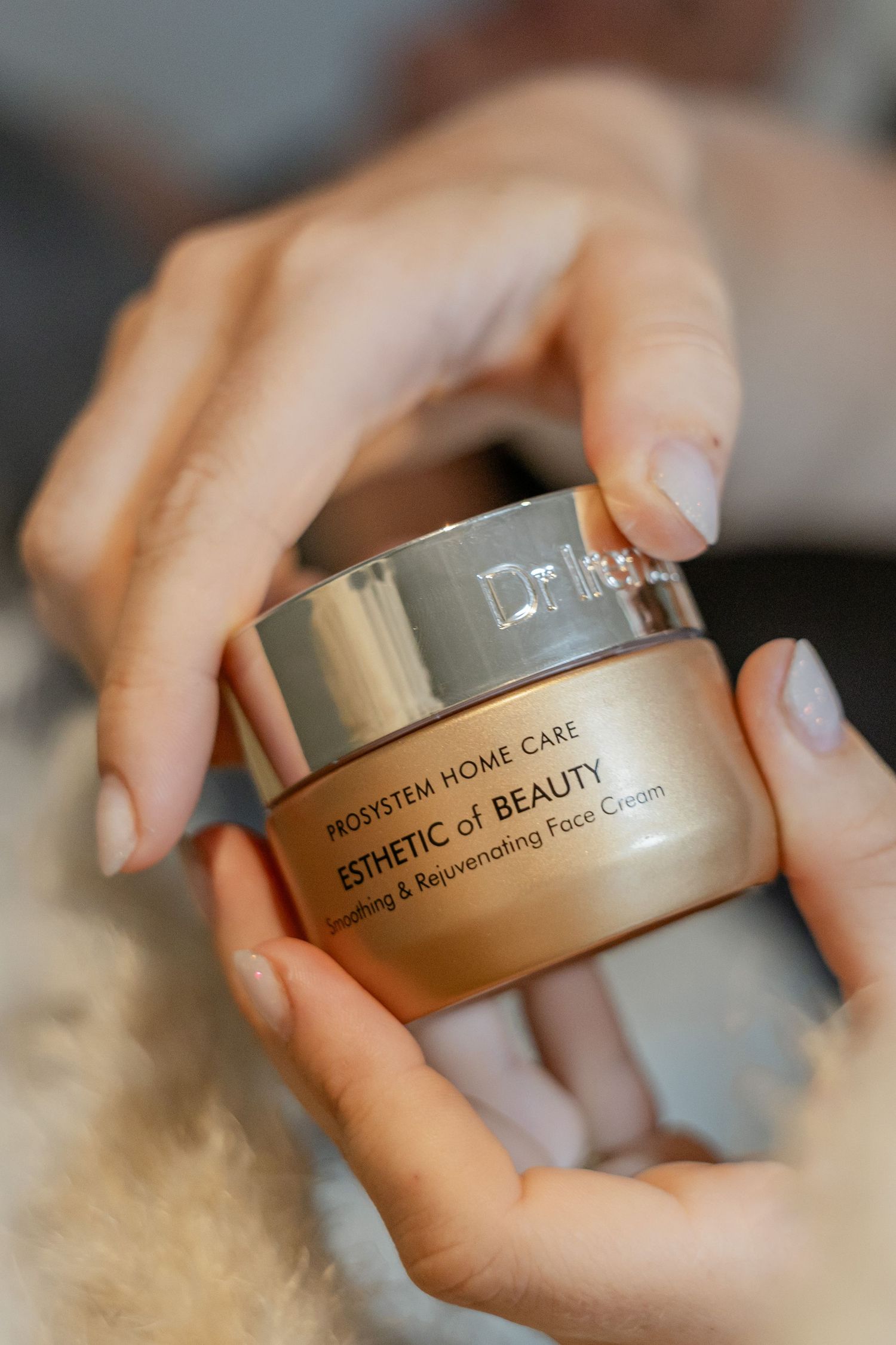 Handen die een pot Esthetic of Beauty Prosystem Home Care verjongende gezichtscrème vasthouden.