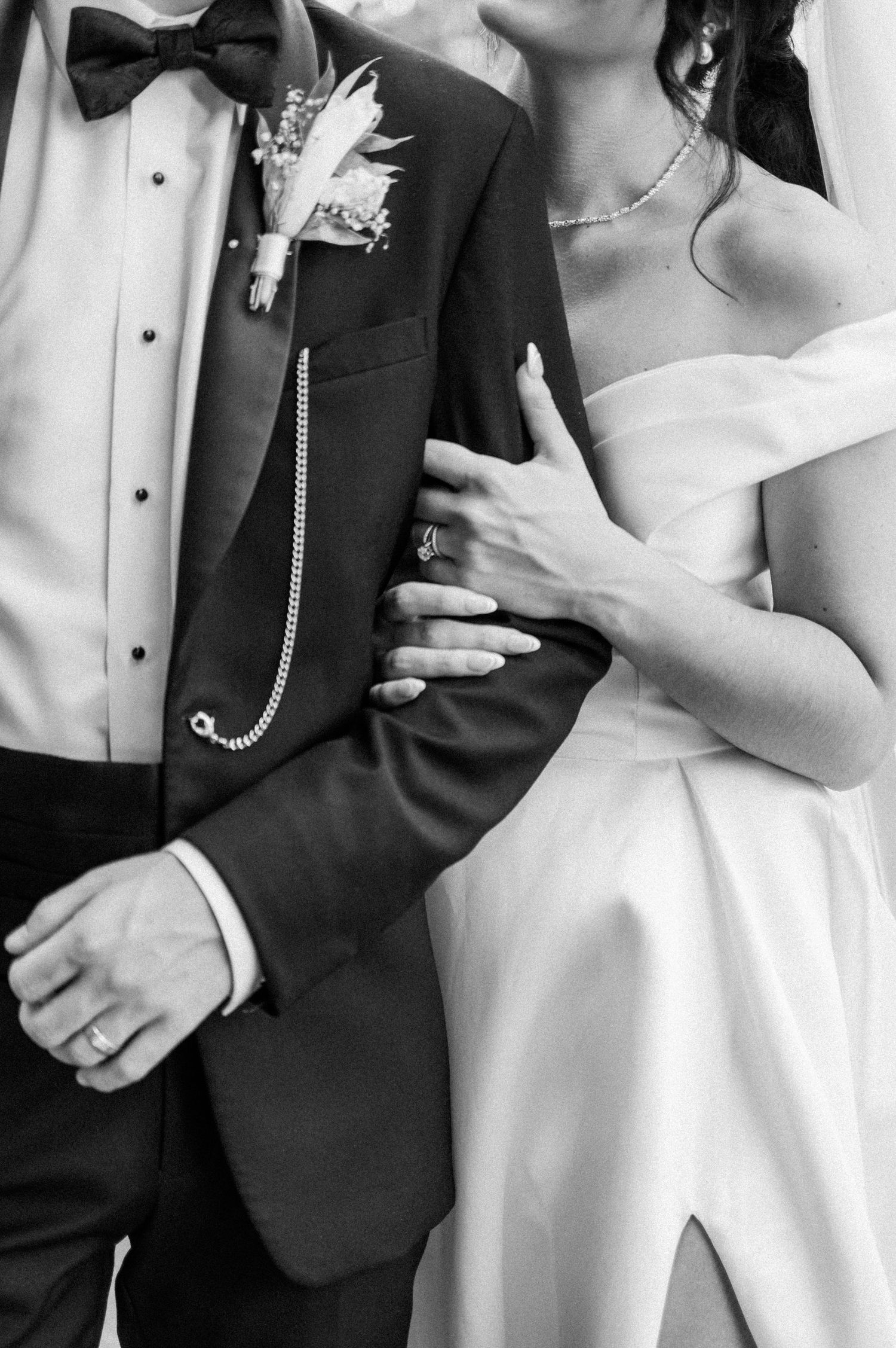 Black and White Bride hugging onto grooms arm detail