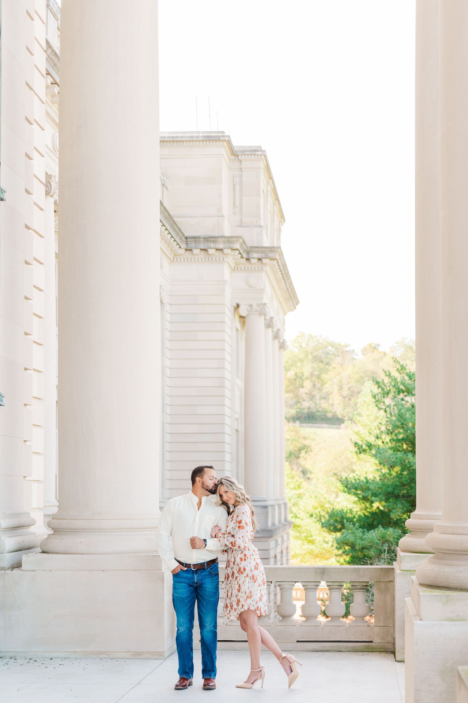 engaged couple at frankfort kentucky state captiol cuddled together between columns