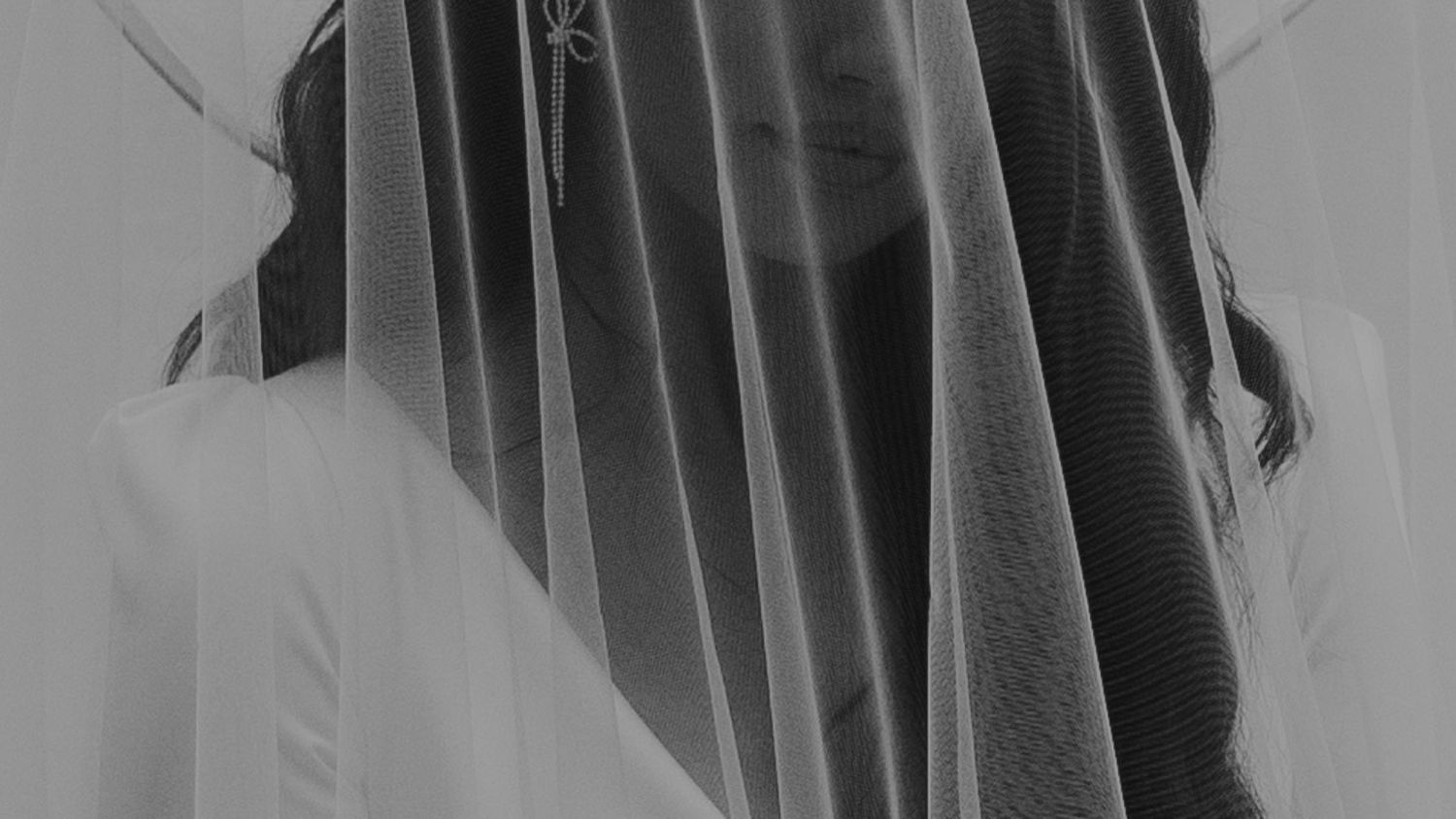Artistic black and white photo showing flowing veil texture and shadows.