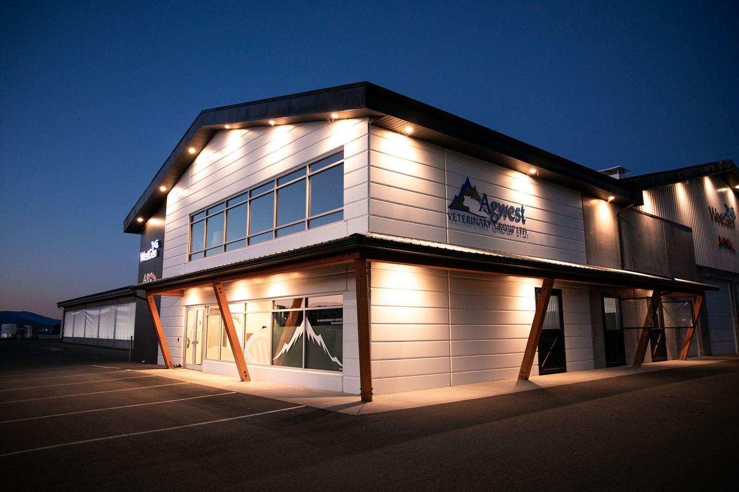 Modern two-story commercial building illuminated at dusk.