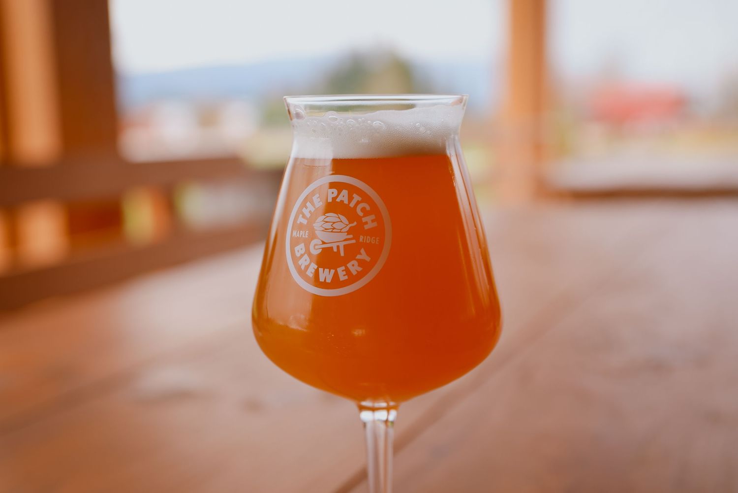 A craft beer served in a branded tulip glass with orange-amber coloring.