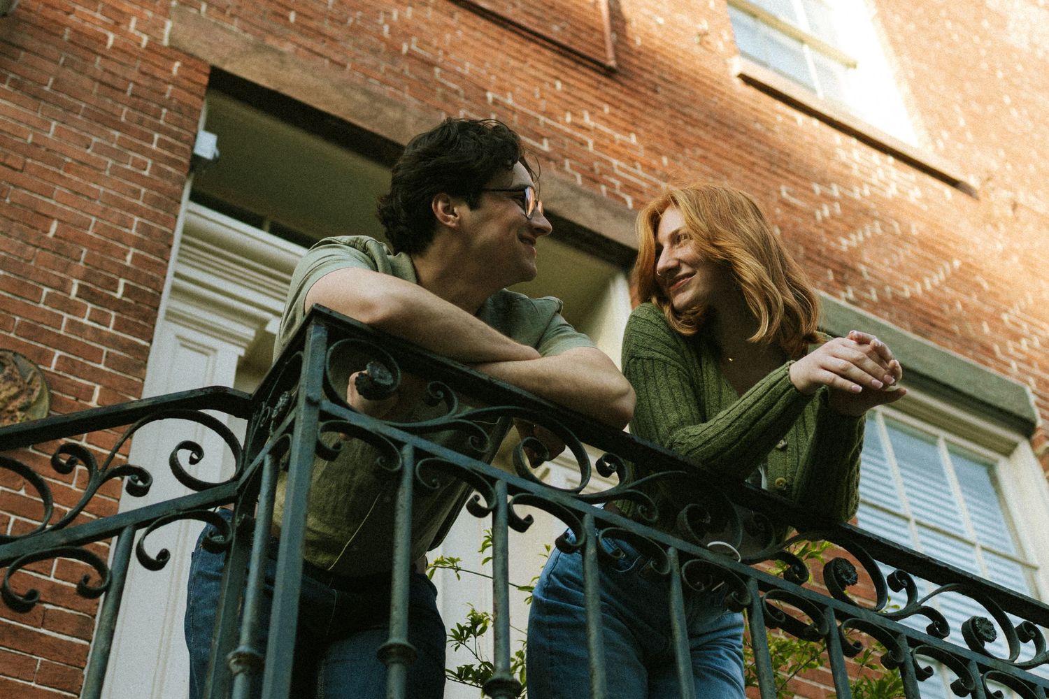 A couple leans over the arm rail on a balcony in downtown Savannah, Georgia