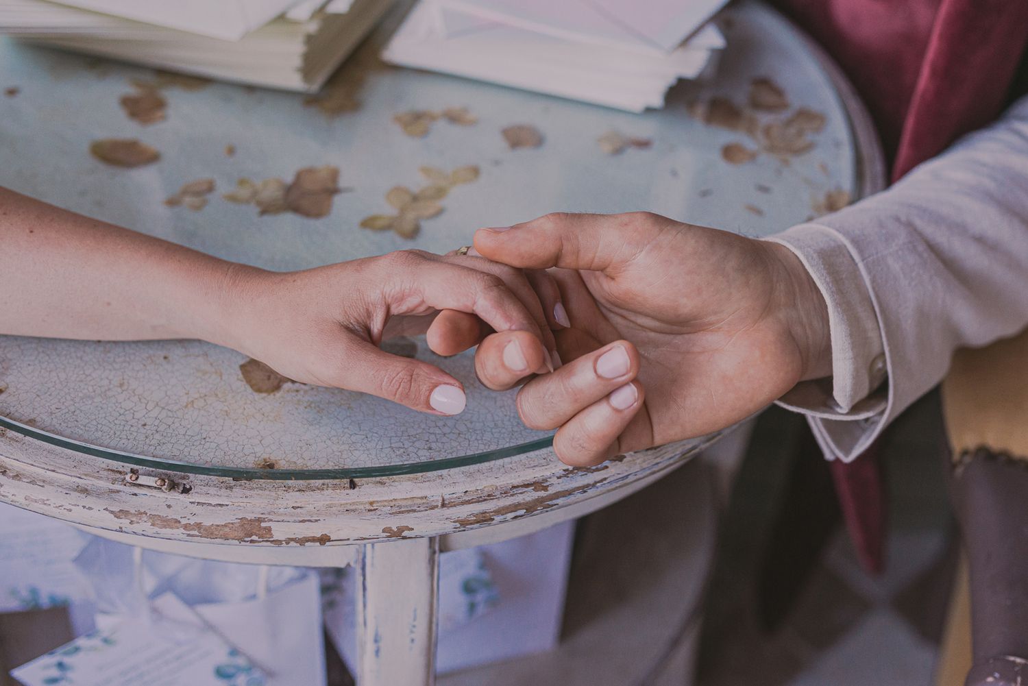 Close-up of hands sorting through papers and documents on a gray surface.