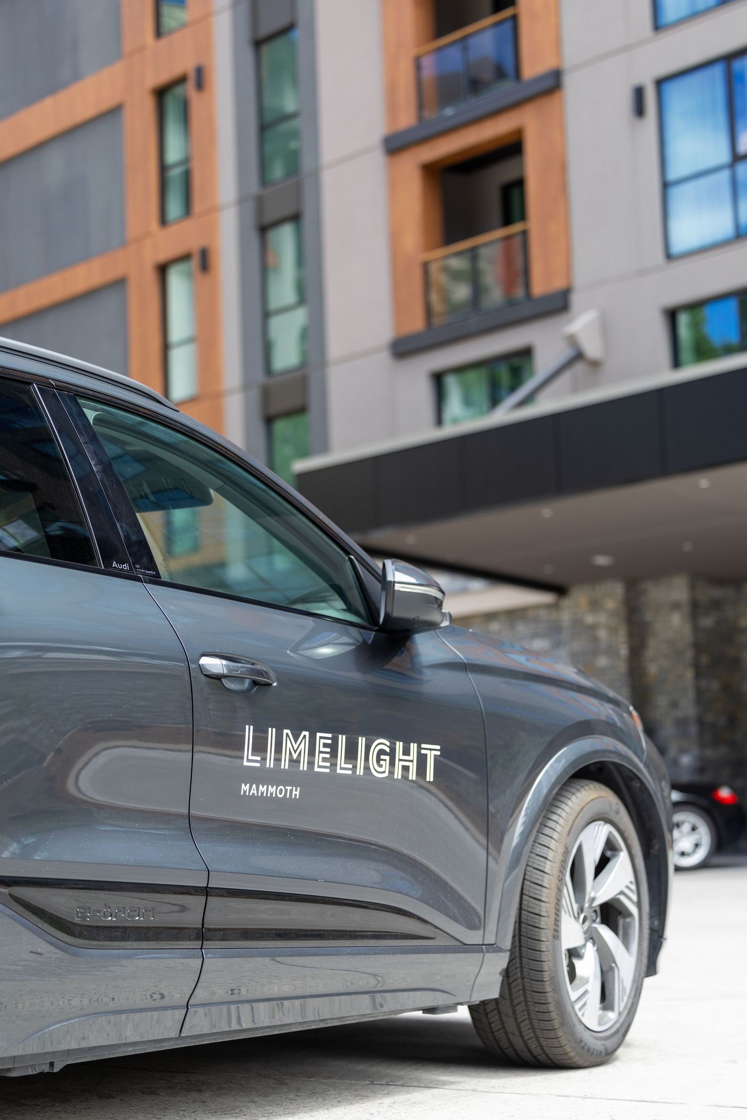 Gray SUV with Limelight Mammoth logo parked in front of a modern hotel building.