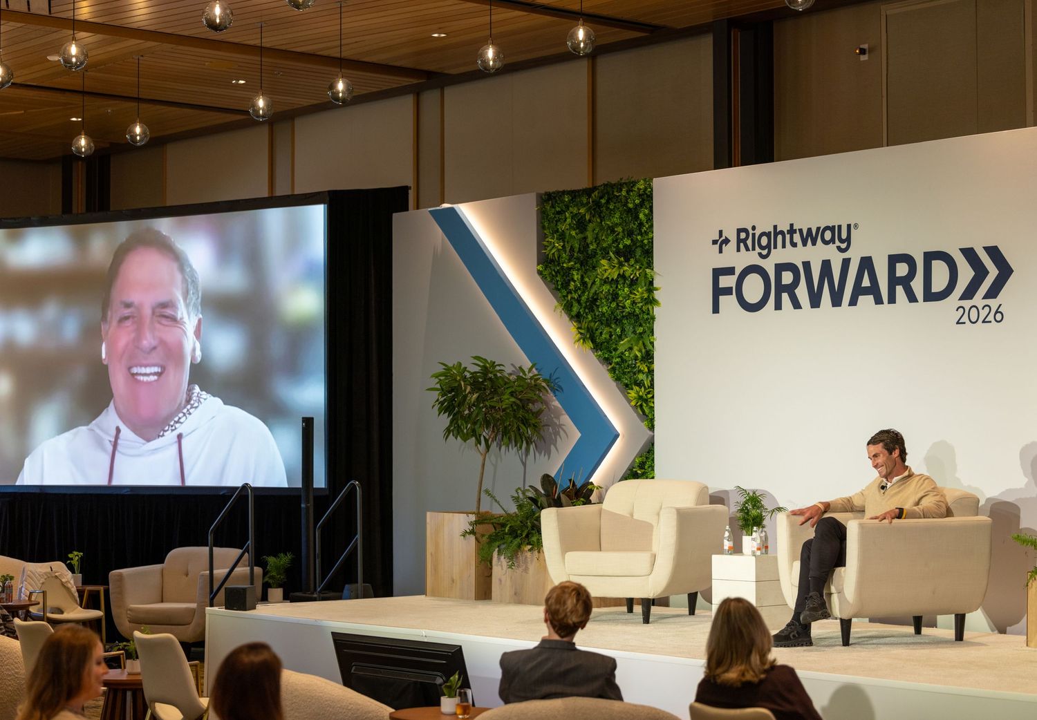 Rightway Forward 2026 conference stage with speaker on screen and moderator seated in modern venue.