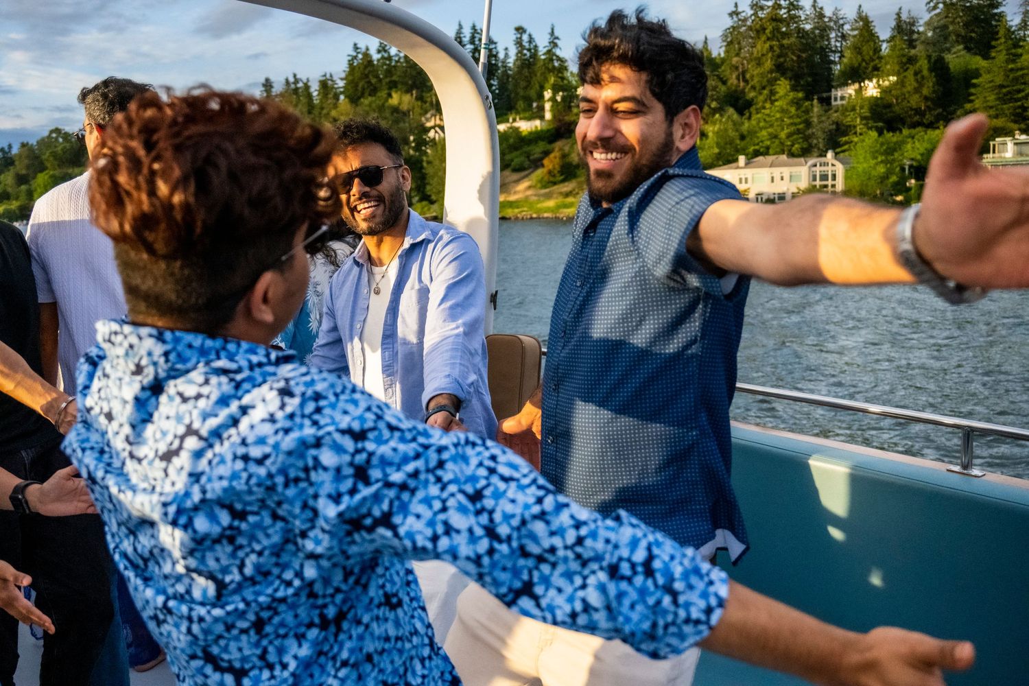 Friends celebrating on a boat deck with scenic waterfront views.