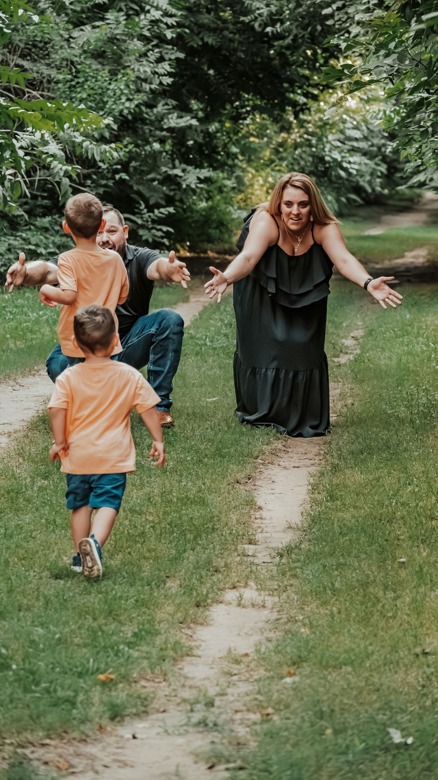 Mother with open arms welcoming her children running toward her on a path.