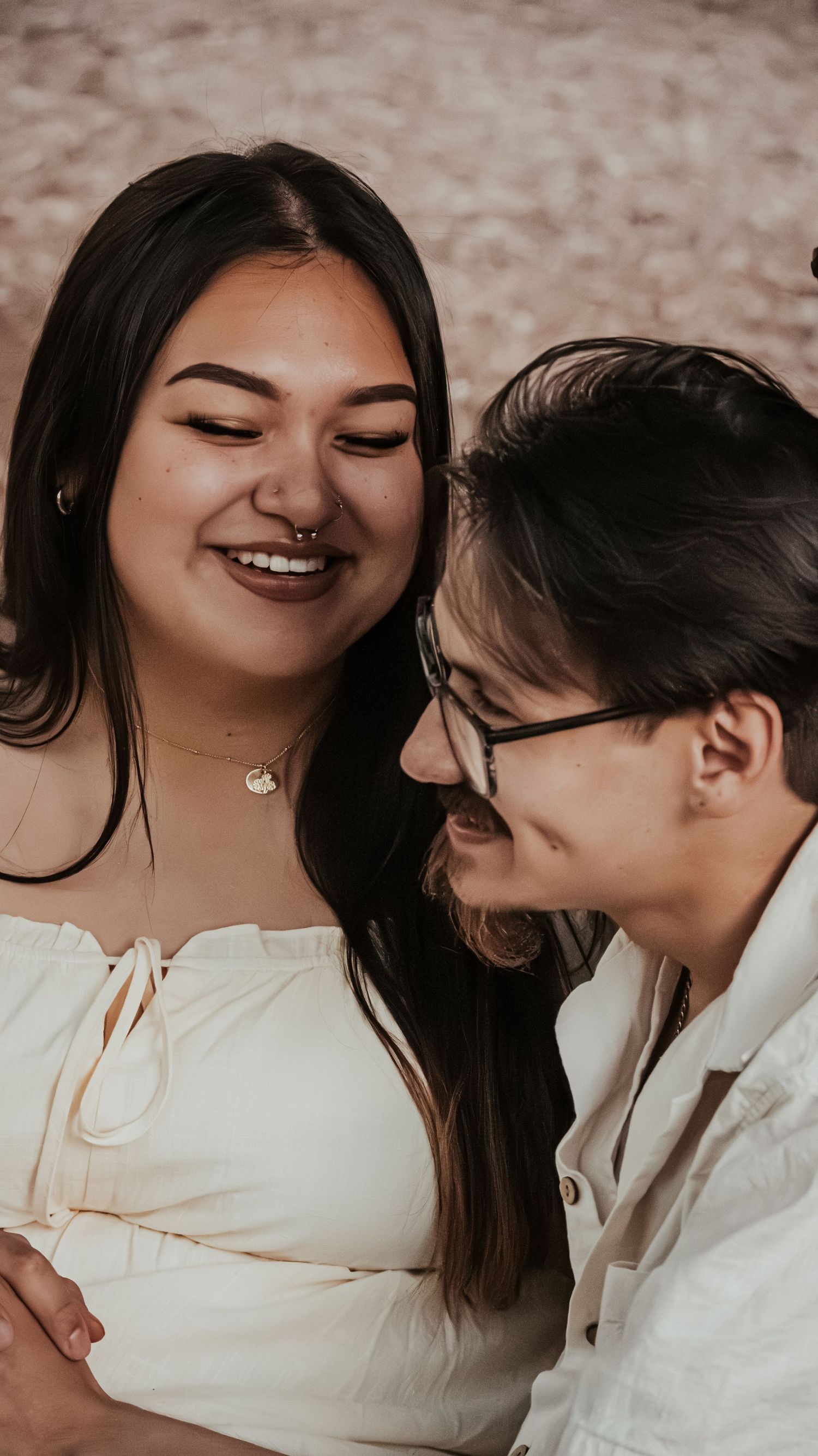 A joyful couple laughs together in a warm and intimate close-up portrait.