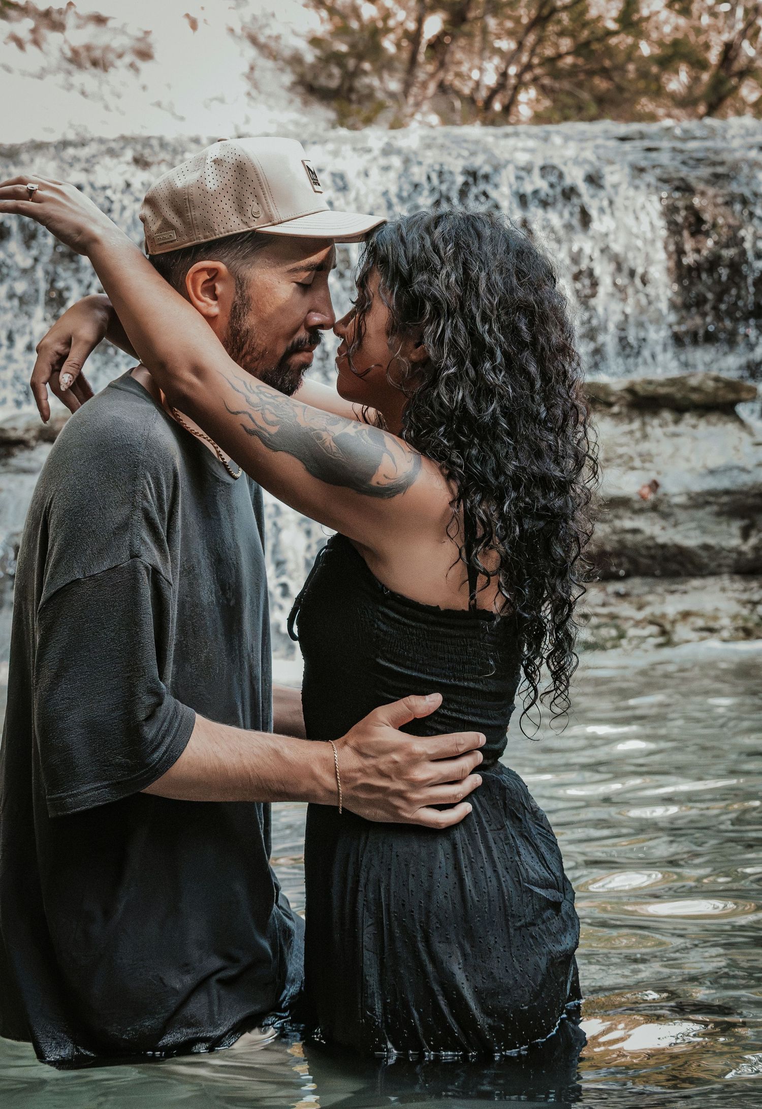 A couple embracing each other, both looking deeply into each other's eyes for a couples session.