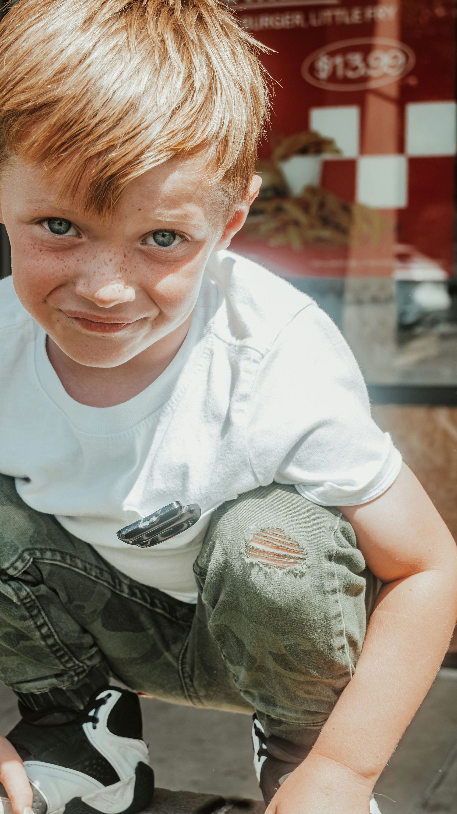 A freckled red-haired boy with blue eyes smiles Family Photographer in Pflugerville, Tx
