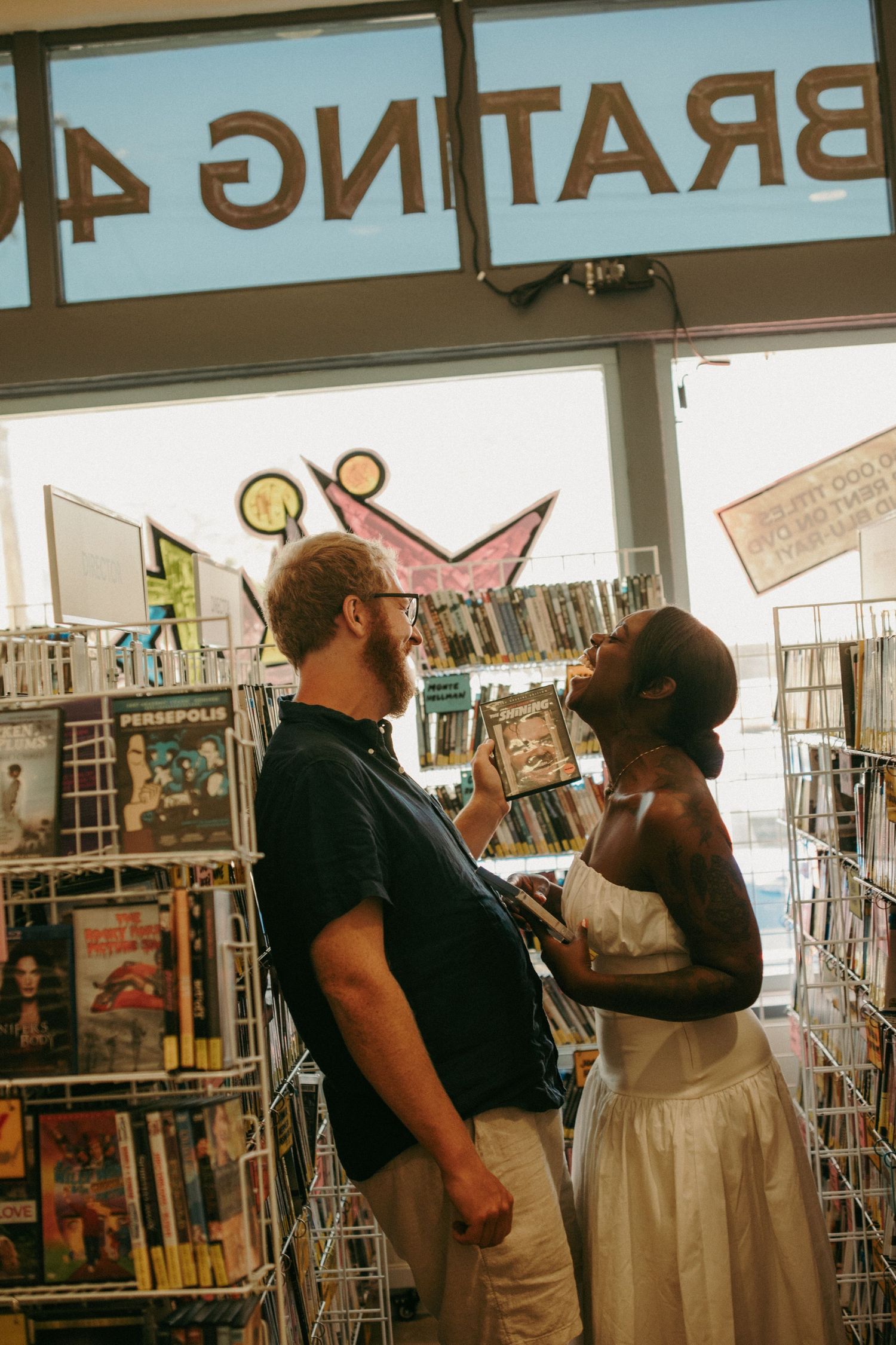 Couple sharing a romantic moment in a comic book store, surrounded by graphic novels and colorful displays.