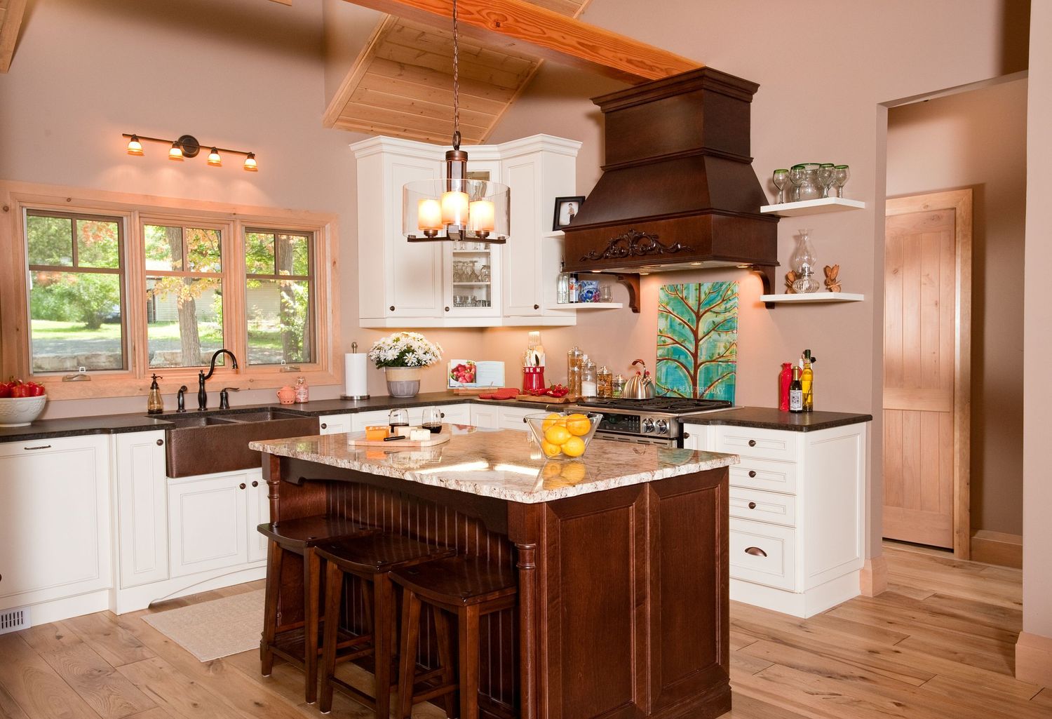 A rustic kitchen features a wooden island with granite countertops, white cabinets, and exposed beam ceiling.