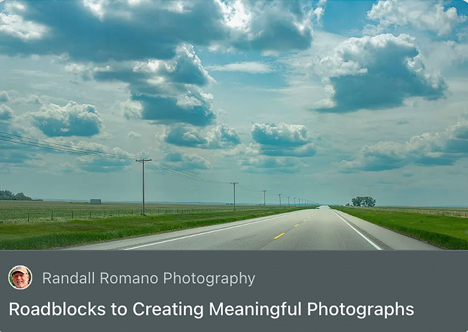 A straight rural highway stretches into the horizon under dramatic cloudy skies, flanked by flat green fields in the Midwest.