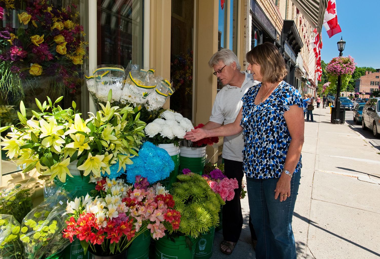 Couple browses colorful fresh flowers displayed outside a charming downtown flower shop.