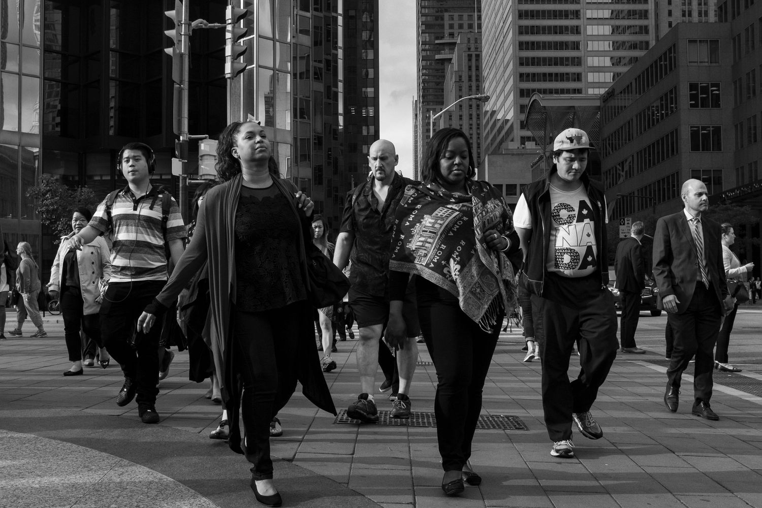 Black and white photo of diverse pedestrians walking confidently on a busy urban city street.