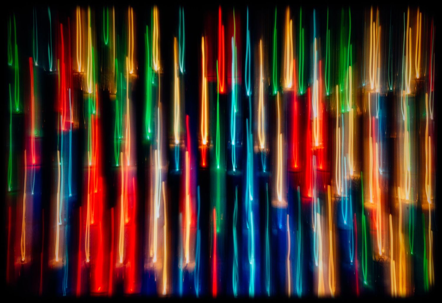 Colorful abstract light streaks in red, green, blue and yellow create a vibrant vertical pattern.