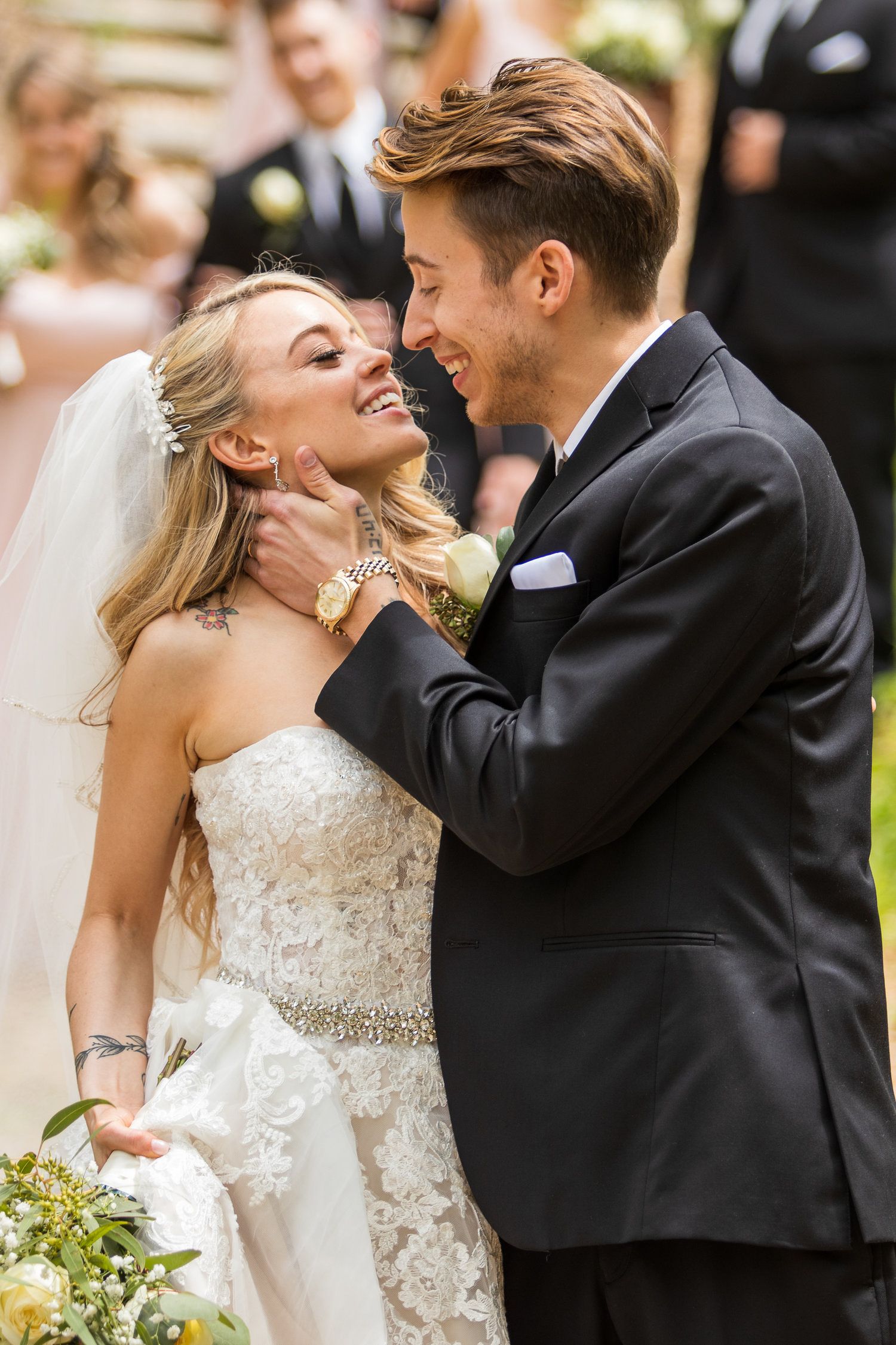 Smiling bride and groom share a tender moment during their outdoor wedding ceremony.