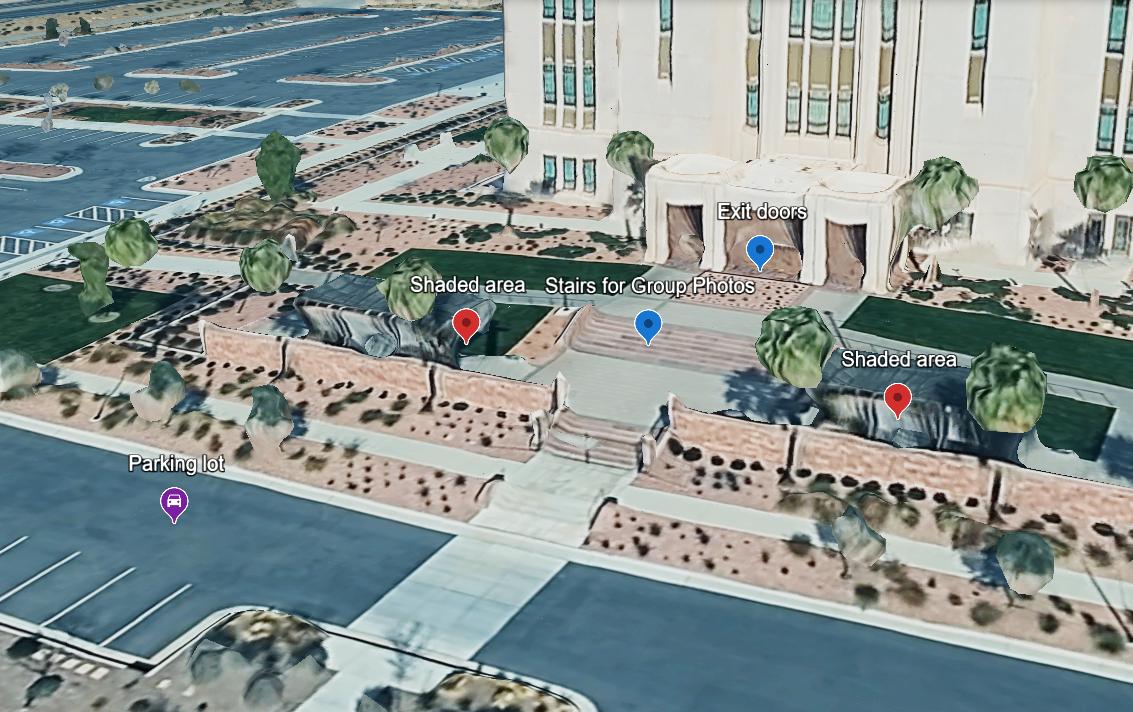 Aerial view of a large government building with landscaped grounds, parking lot, and marked locations in a sunny desert city.