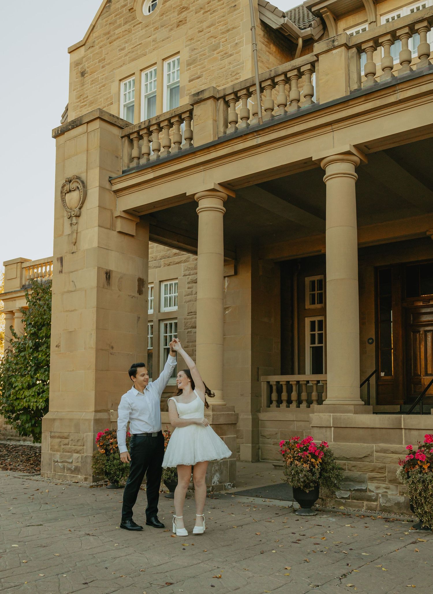 An engaged couple embracing outside Government House in Edmonton, Alberta, during their engagement photography session.