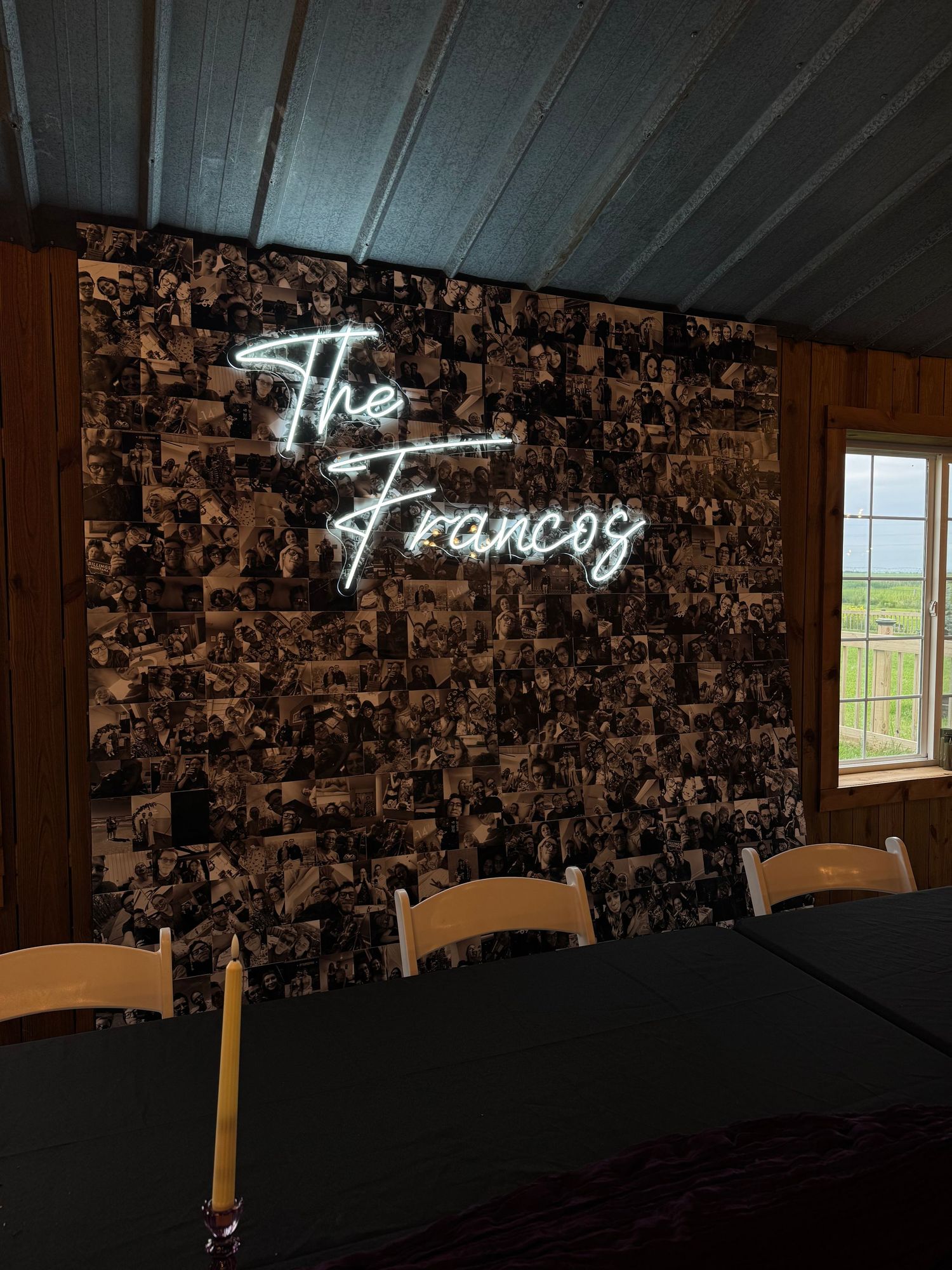 Neon sign reading The Francos displayed on a black and white photo collage wall.
