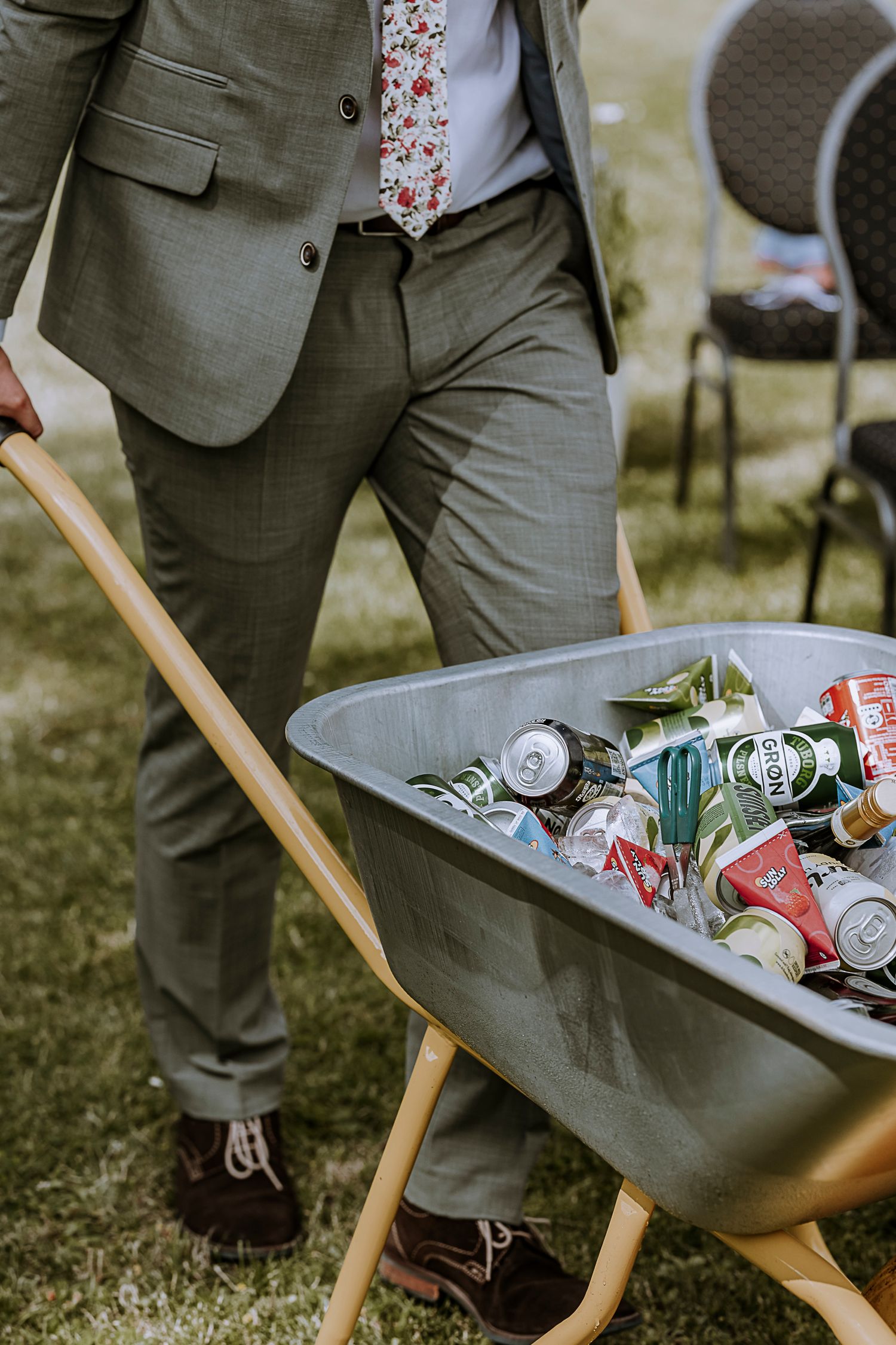 Wheelbarrow filled with drinks and ice at outdoor garden party.