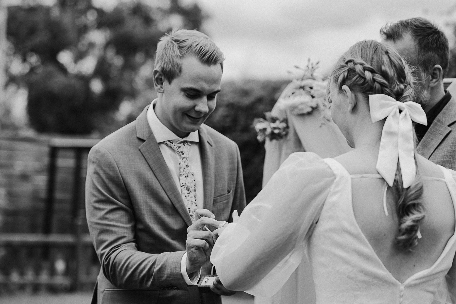Wedding ceremony moment captured in black and white during outdoor celebration.