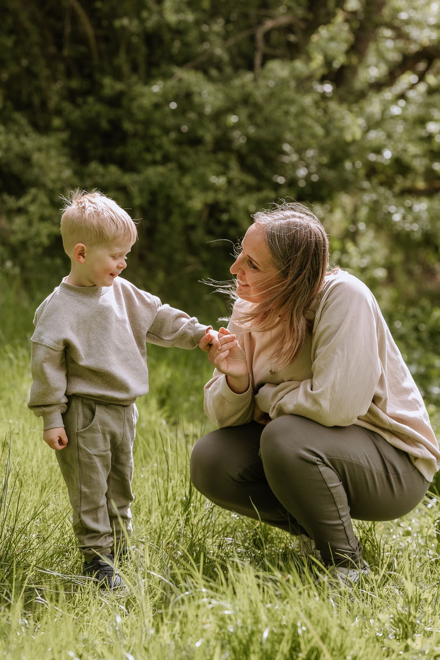 An intimate moment of connection between parent and child in a sunlit spring meadow.