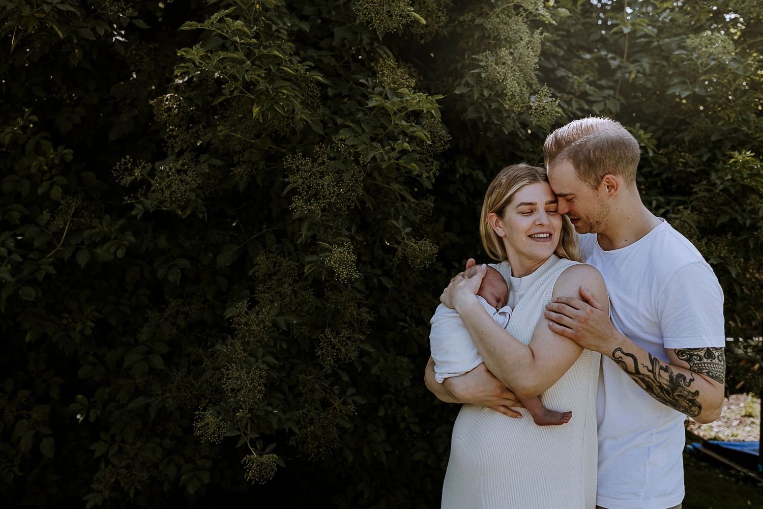 Couple embracing and laughing together in outdoor forest setting.